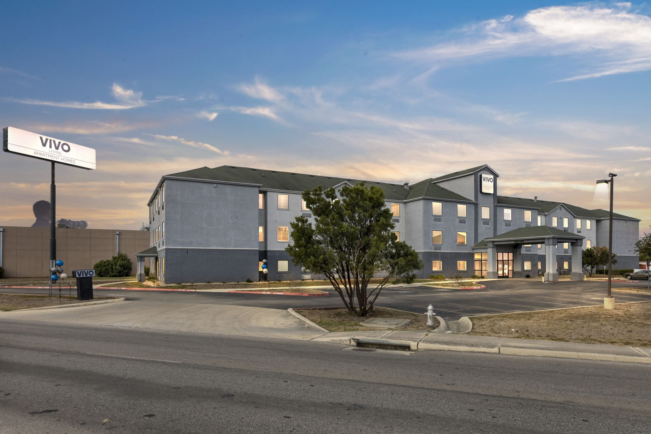 Vivo Living New Braunfels apartment homes in New Braunfels, TX, captured at dusk with clear skies and exterior lighting visible.